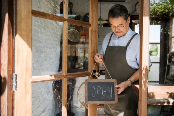 Small business owner at a shop entrance